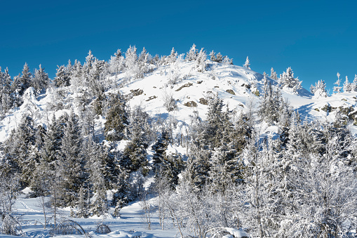 Kolyma track in winter against the background of snow-capped mountains