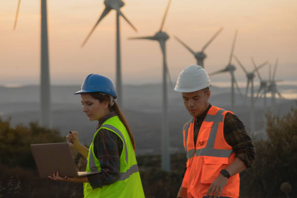 istock Maintenance engineer team working in wind turbine farm at sunset 1957469128