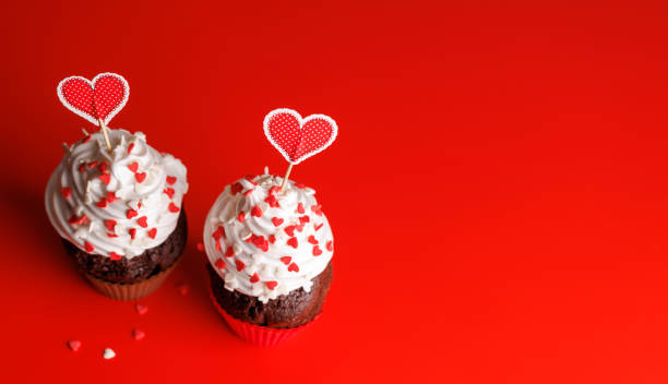 istock Cupcake love: Heart-themed treats on a vibrant red backdrop 1957484971