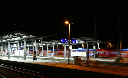 Trains waiting at the illuminated platforms of a big station