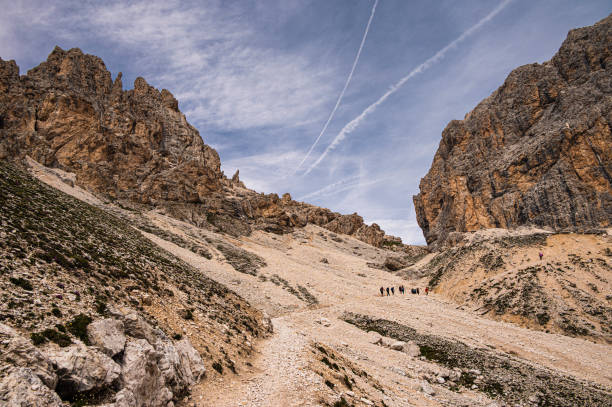 nature sceneries along a trail inside the Catinaccio mountain range with a cloudy sky in the background, Val di Fassa, Dolomites, Italy