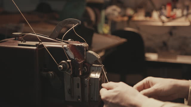 Shoemaker Using Old-Fashioned Sewing Machine in Workshop