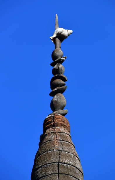 A 'fleche faitiére', symbol of the Kanak people and central element of the Kanak flag, Nouméa, New Caledonia Nouméa, South Province, New Caledonia: a 'fleche faitiére' (rooftop arrow) at the center of Mwaka Square, Maréchal Foch Avenue, downtown Nouméa - an indigenous Melanesian symbol that came to represent the Kanak people and the independence movement (FLNKS).  A respected emblem of the Kanak chiefdom, the 'fleche faitiére', is a traditional element of Kanak architecture, which dominates and adorns the cone-shaped thatched roof of the large huts and ceremonial totems of a clan. It is made with houp (Montrouziera cauliflora), a rot-proof wood from high-altitude forests and has a a calling conch at the top. fleche stock pictures, royalty-free photos & images