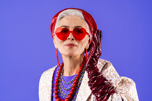 Happy and funny senior old woman wearing fashinable clothing on colorful background- Modern cool fancy grandmother portrait, concepts about elderly and older people