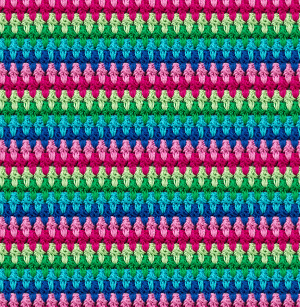 Seamless knitted texture in afghan style. The pattern is crocheted from multicolored cotton yarn. Textured blanket.