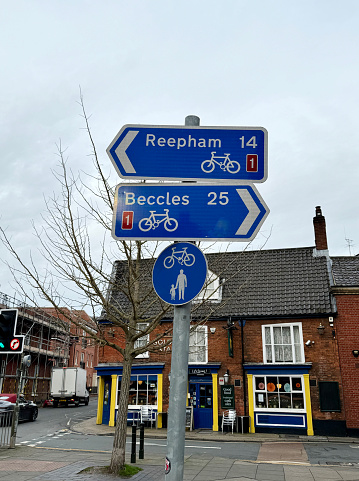 Directional sign for cycle routes to Reepham and Beccles on an urban street in Norwich. January 2024