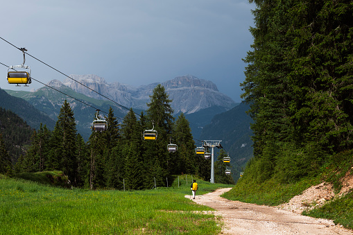 nature sceneries along a trail inside the Catinaccio mountain range with a cloudy sky in the background, Val di Fassa, Dolomites, Italy