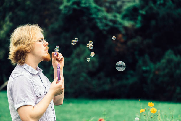 ... blowing a big bubble for a baby, looking through that bubble
