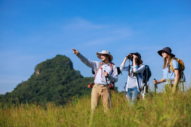 istock family trekking backpacker pointing finger and using binoculars to see view, 1957552913