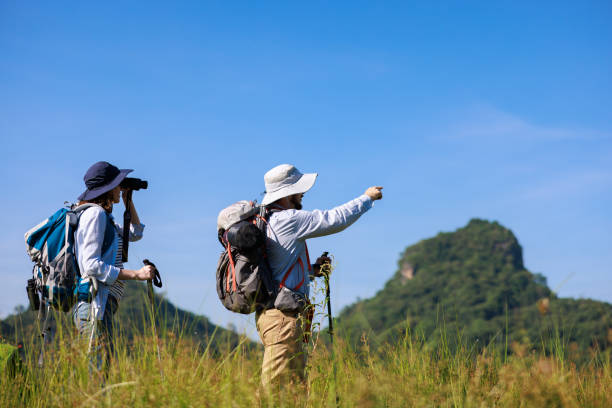 istock family trekking backpacker pointing finger and using binoculars to see view, 1957554273