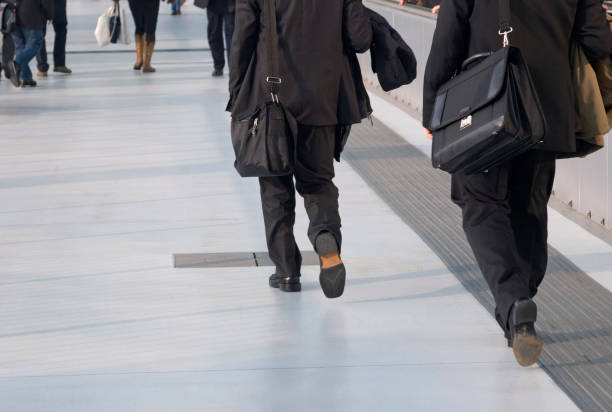 Man in full suit and with suitcase leaving the hotel, calling taxi and coming to the airport or train station, ready for his business trip. While waiting for check-in, man is drinking coffee and reading newspapers.