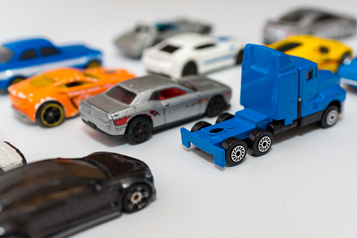 Colorful miniature toy car collection on light background selective focus on the blue truck.