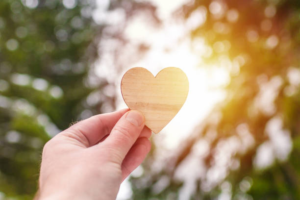 istock Man palm holding heart on blurred winter sunset forest trees.Valentine's day concept.copy space. 1957598260