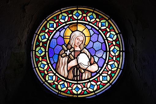 Mahébourg, Grand Port District, Mauritius: Notre Dame Des Anges, backlit triple stained glass window displaying Jesus on the cross and the Virgin Mary.