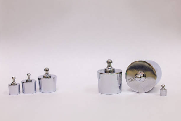 Metal laboratory calibration weights for scales on a white background