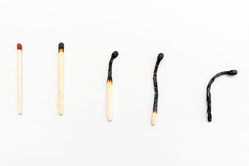 Row of burnt matches and whole one on white background, top view,closeup. Human life phases concept or Concept of different phases in human life.Selective focus.