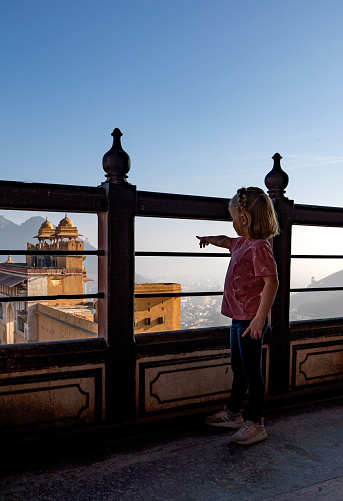 Young girl enjoying the beautiful historic Amber Palace or Amber Fort in Jaipur, Rajasthan, India Asia.
