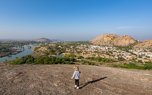 Young girl enjoying an overlook of the dramatic boulder covered landscape in the Jawai region of Rajasthan, India Asia.