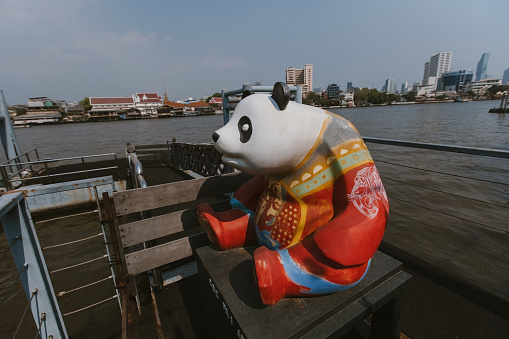 Panda figure sitted on the pier of Chao Praya river in Bangkok Thailand