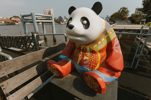 Panda figure sitted on the pier of Chao Praya river in Bangkok Thailand