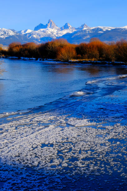 Grand Tetons Mountain Range or Teton Mountains with snow and sunset light with river and ice