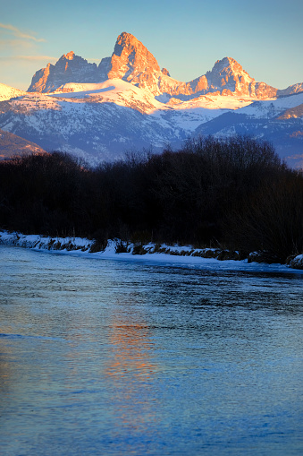 Grand Tetons Mountain Range or Teton Mountains with snow and sunset light with river and ice