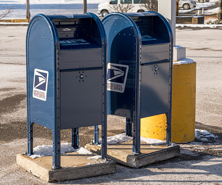 A line of mailboxes with pink, blue and green complimentary colors.