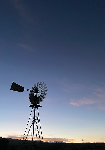 Silhouet of a windmill during sunset in the outback of South Africa