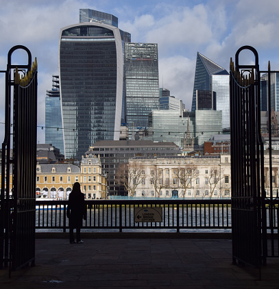 London, UK - January 22 2024: A person walks past the City of London skyline, the capital's financial district.