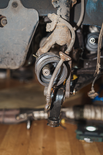 Close up of a shock-absorber shackle, control arm, half shaft, drive shaft and spring.