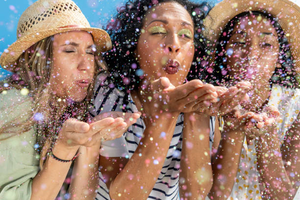 istock Three women blowing glitter from hands 1957741117