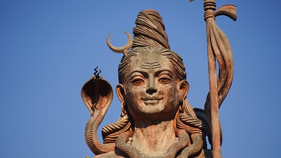 face statue of god shiv holding trishul