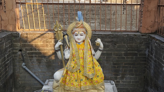 sculpture of lord shiva wearing yellow cloth in temple