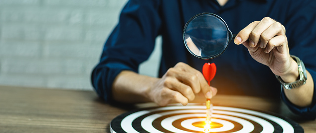 Businesspeople Point to a darts aiming at the target center business,Targeting the business concept. red arrow dart target dart board. Setup objectives and target for business investment concept.