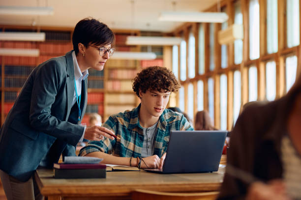 istock Female professor assisting her student in learning on laptop in the classroom at high school. 1957774708