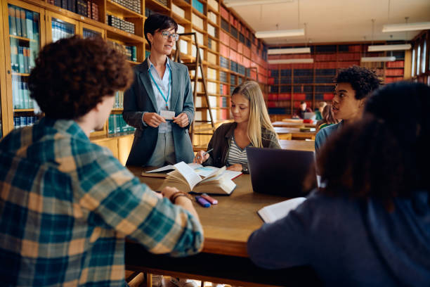 istock Female teacher with group of high school students during a lecture in library. 1957775232
