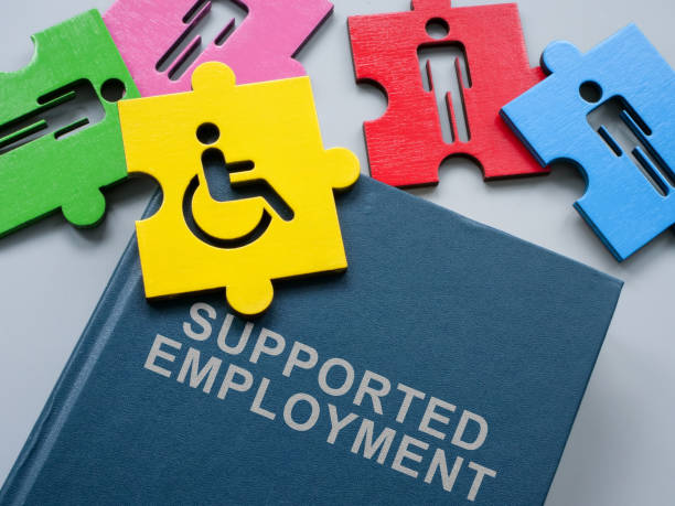 istock Book supported employment and pieces of puzzle. 1957852935