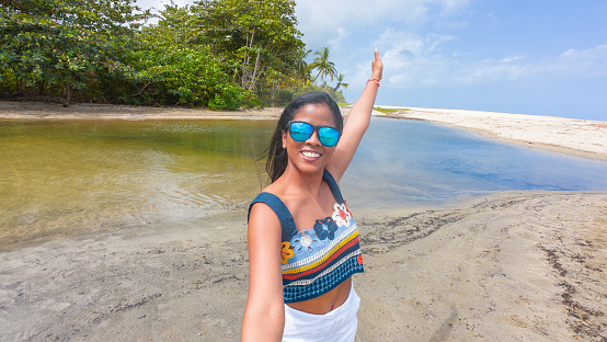 Latin Woman Waving on Tropical Beach