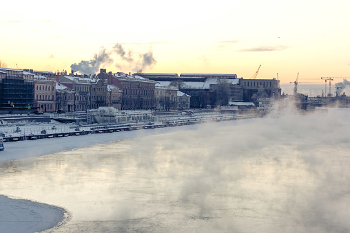 Evening mist over river, embankment with a row of historic buildings, St.Petersburg, Russia