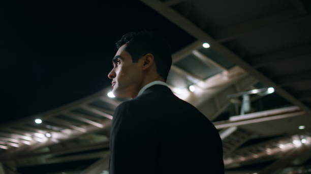 Calm employee admiring evening architecture back view. Man going to dark airport