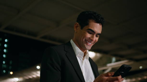 istock Happy man reading phone message crossing night close up. Smiling manager walking 1958006663