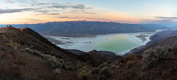 Breathtaking sunrise view from Dante's View. Gaze upon the soft pink hues painting the sky, transforming the salt flats of Badwater Basin into frozen lake. Across the horizon, a majestic range of mountains completes this visual masterpiece