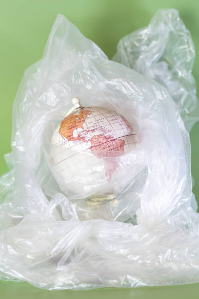 istock The Earth surrounded by plastic on a green background. Vertical 1958055190
