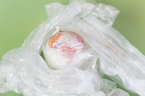 istock The Earth surrounded by plastic on a green background. Horizontal. 1958055194