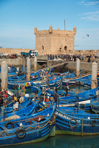 The blue fishing boats, fishing nets and in the background the tower of the Sqala