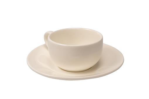 Close-up of a single empty bone China footed tea cup and saucer with a flower pattern, made in England, from directly above standing on a wooden table