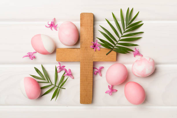 istock Pink Easter eggs with cross and leaves on wooden background, top view 1958134285