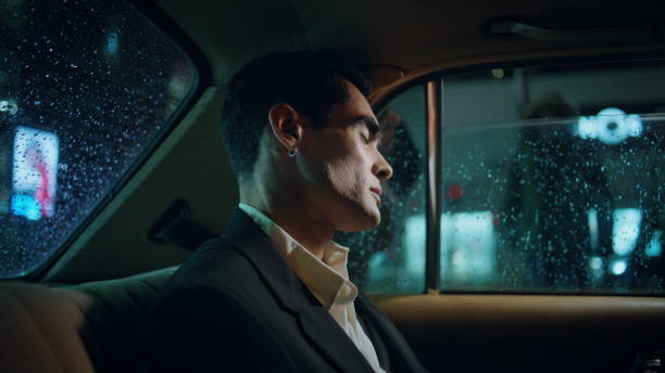 istock Sleeping entrepreneur napping rainy window car close up. Pierced man having rest 1958146962