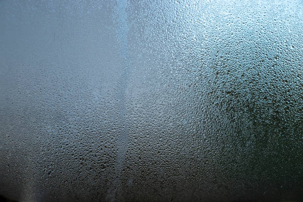 istock Close-up image of water droplets creating patterns on clear glass. 1958159881
