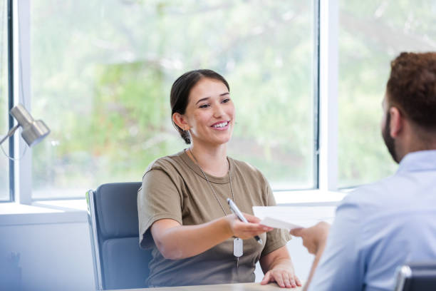 istock Female soldier smiles while giving banker completed paperwork 1958189453